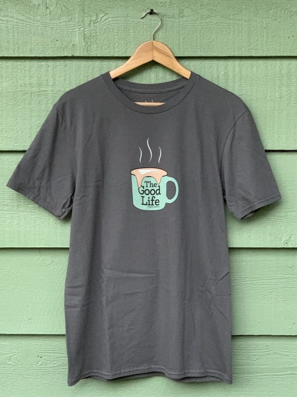 Front of Livin' Light's The Good Life coffee mug shirt with overflowing froth heart. The extra-large light green mug pops out from the dark gray shirt. The design illustrates the fulfillment God's abundant love for us.