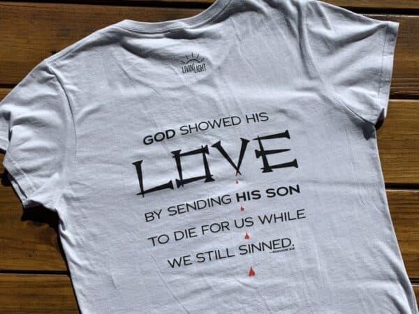 Back of Love short-sleeved in light gray, women's cut. Romans 5:8 says: "God showed His love by sending His Son to die for us while we still sinned."