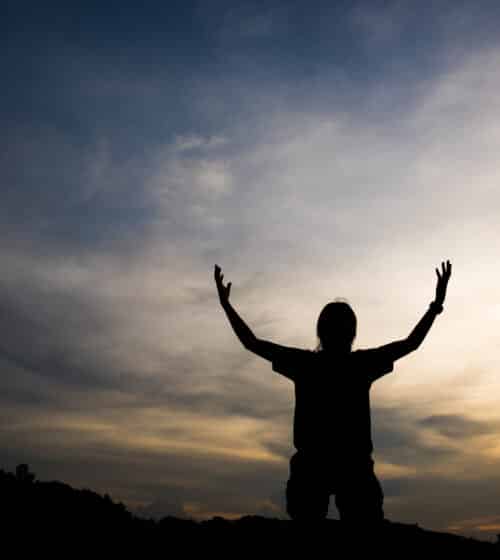 Helpless without God. Silhouette of woman raising her hands to the sky, praying with God